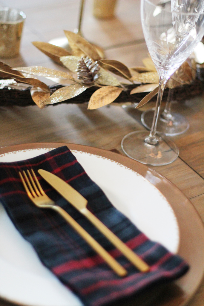 Holiday table setting.  Plaid Napkins Christmas tablescape. Gold accents.  
