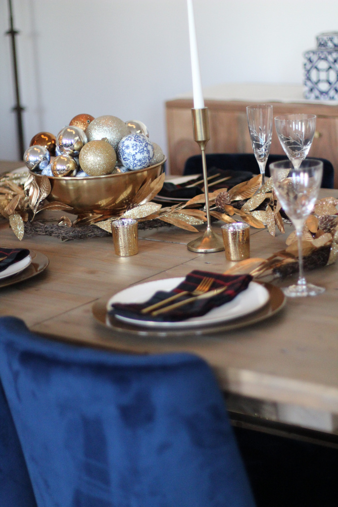 Holiday table setting. A blue Christmas tablescape. Gold accents. Blue dining room chairs.