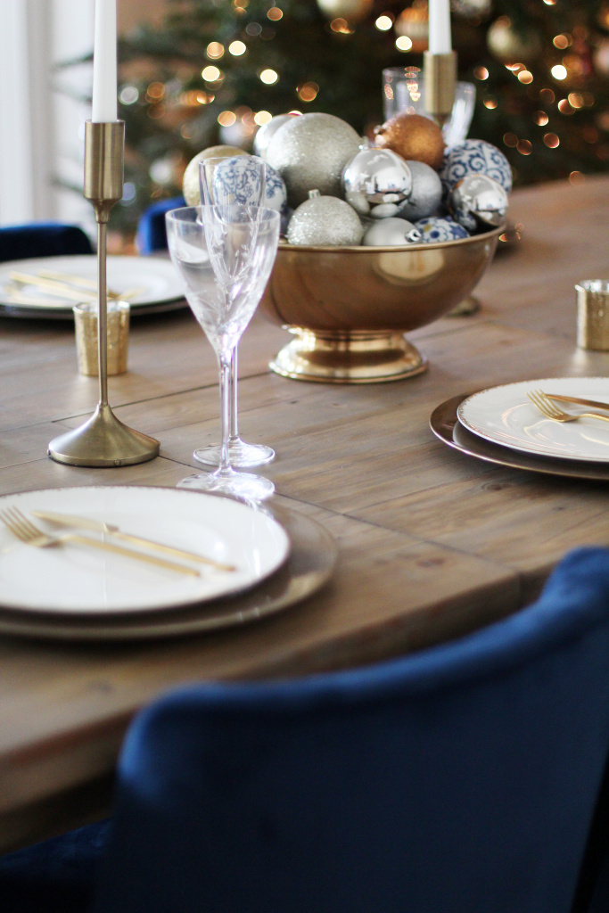 Holiday table setting.  A blue Christmas tablescape. Gold accents. Blue dining room chairs. Gold 